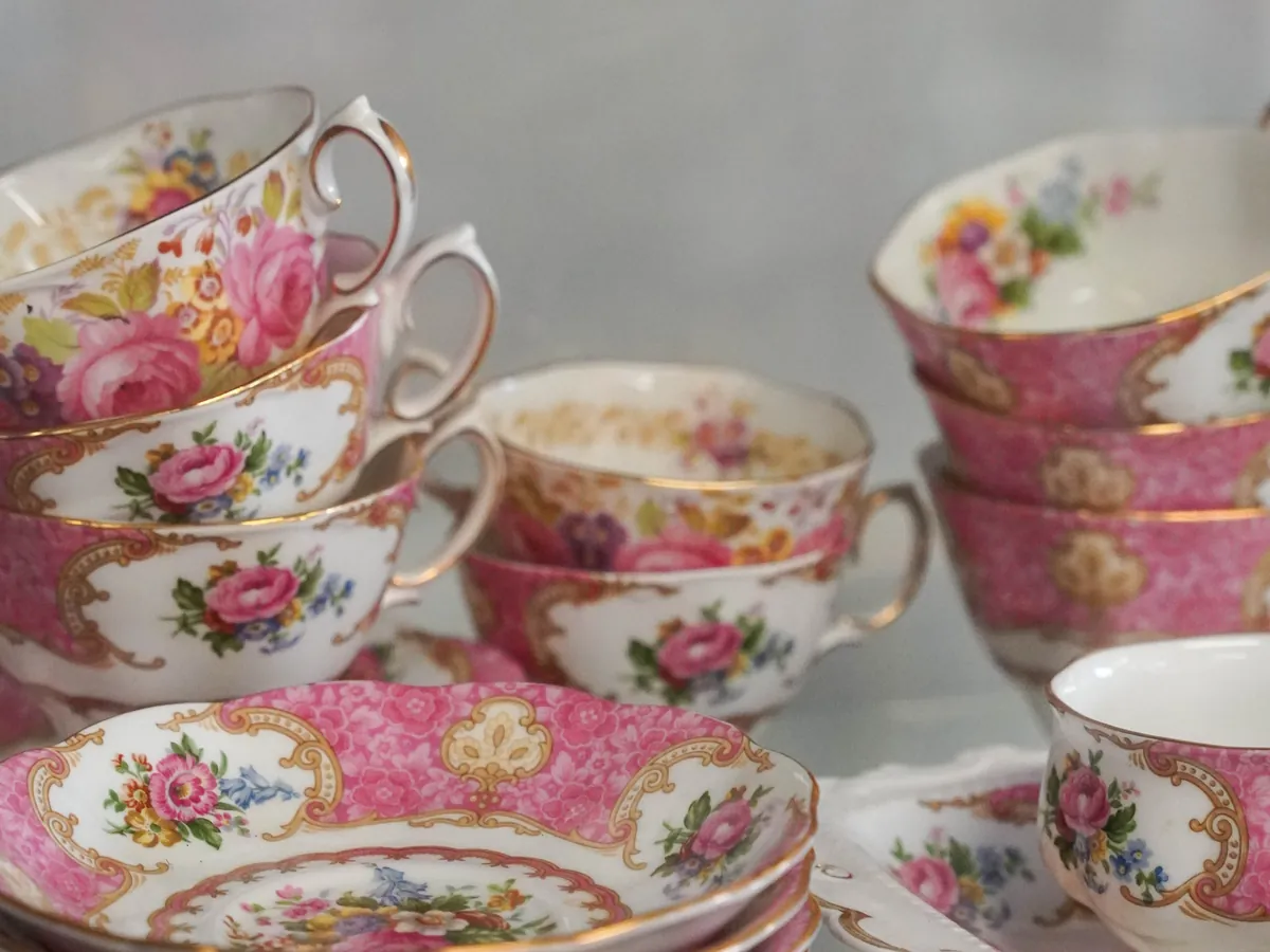 Roze theekopjes met bloemen op een glazen plank